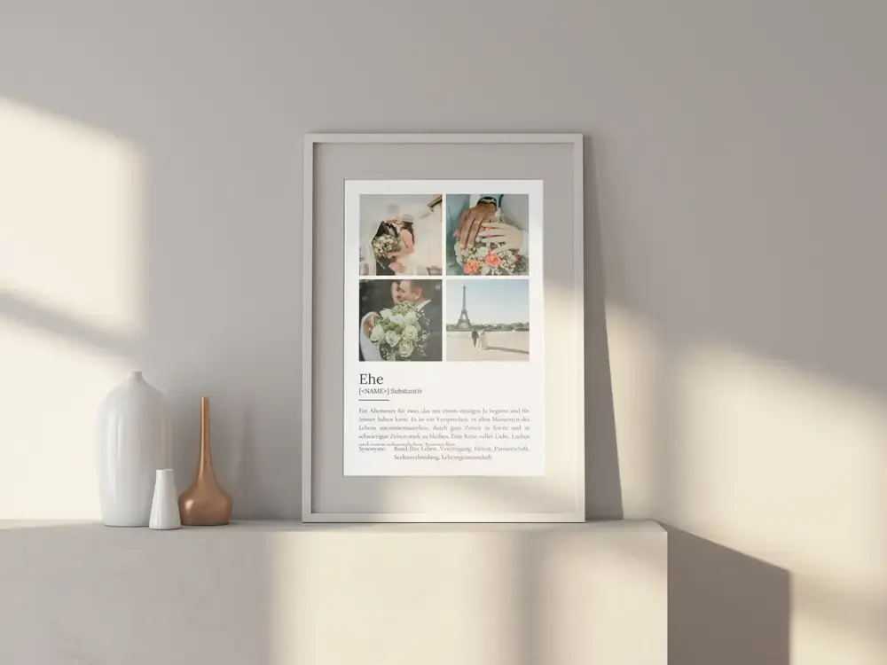 Definitionsposter zur Ehe mit vier Fotos von Brautpaar, Ringen und Blumen im weißen Rahmen auf einem hellen Sideboard
