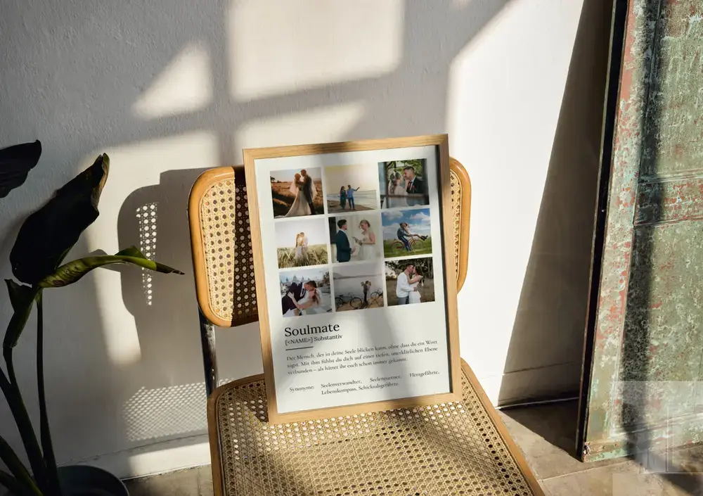Definitionsposter mit neun Paarfotos auf cremefarbenem Grund im Holzrahmen, auf einem Geflechtstuhl