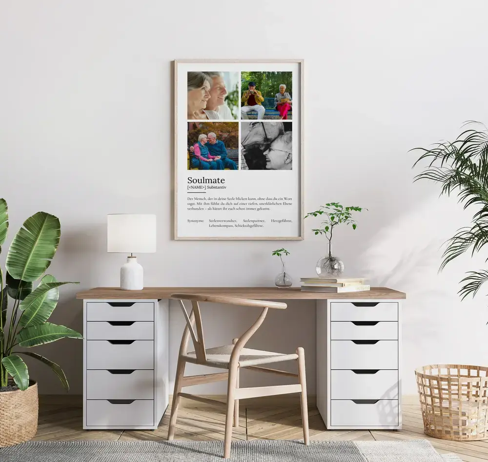 Definitionsposter mit vier Paarfotos und Text im hellen Holzrahmen über einem Schreibtisch, umgeben von Pflanzen
