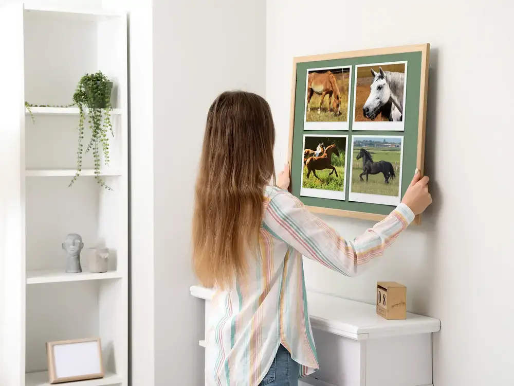 Pferde-Fotocollage in Polaroid-Optik im Naturholzrahmen über dem Kamin in einem hellen Wohnraum
