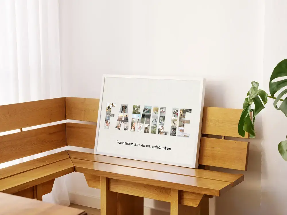 Familienfotocollage in Buchstabenform mit Spruch, im weißen Rahmen auf einer Holzeckbank neben einer Grünpflanze