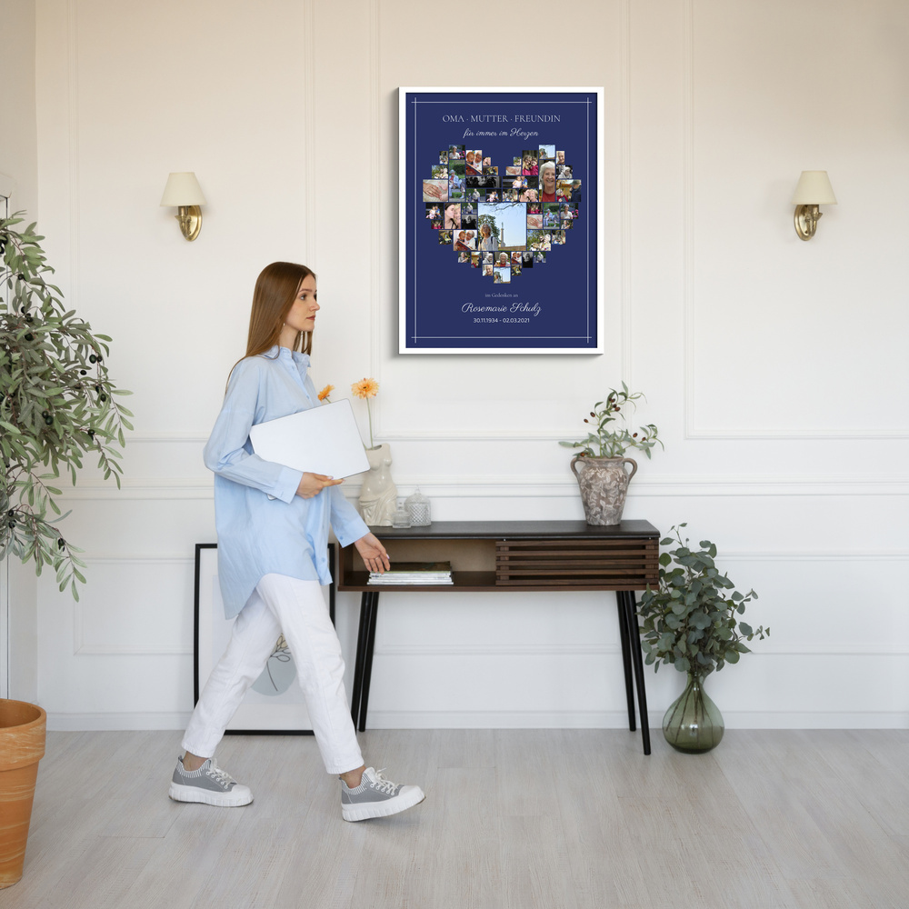 Weiß gerahmte Trauercollage mit Fotos in Herzform auf Dunkelblau über einem Konsolentisch im hellen Raum
