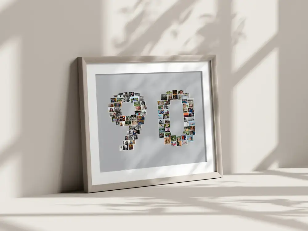 Gerahmte Fotocollage Zahl 90 mit grauem Hintergrund, am Boden an eine sonnige Wand gelehnt