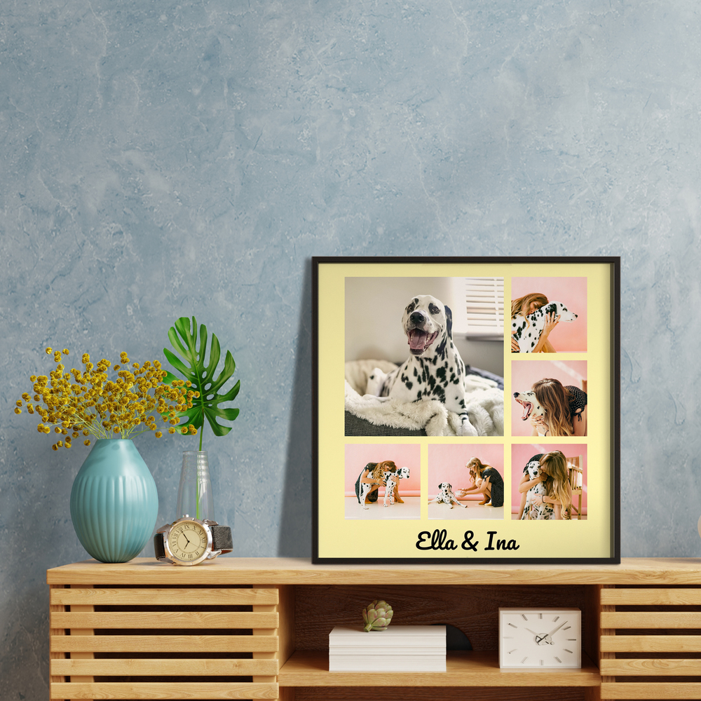 Hunde-Fotocollage mit Namen im schwarzen Rahmen auf einem Holzsideboard vor blauer Wand, neben einer Vase